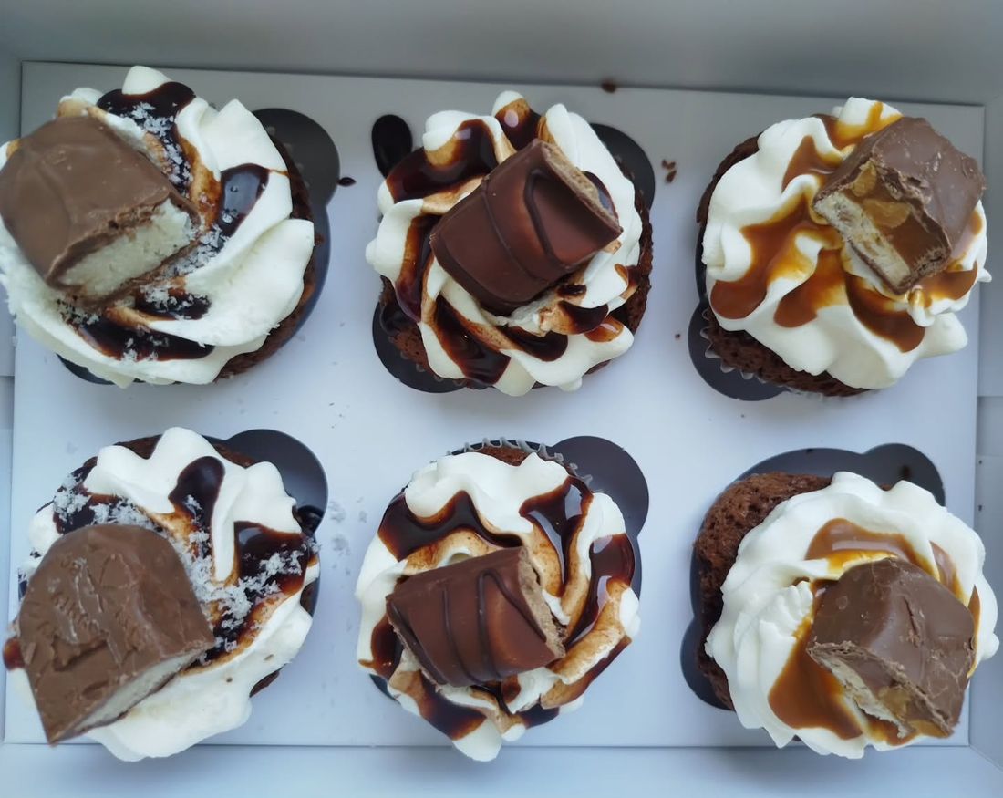 Six cupcakes chantilly, sauce chocolat et caramel, morceaux de barres chocolatées