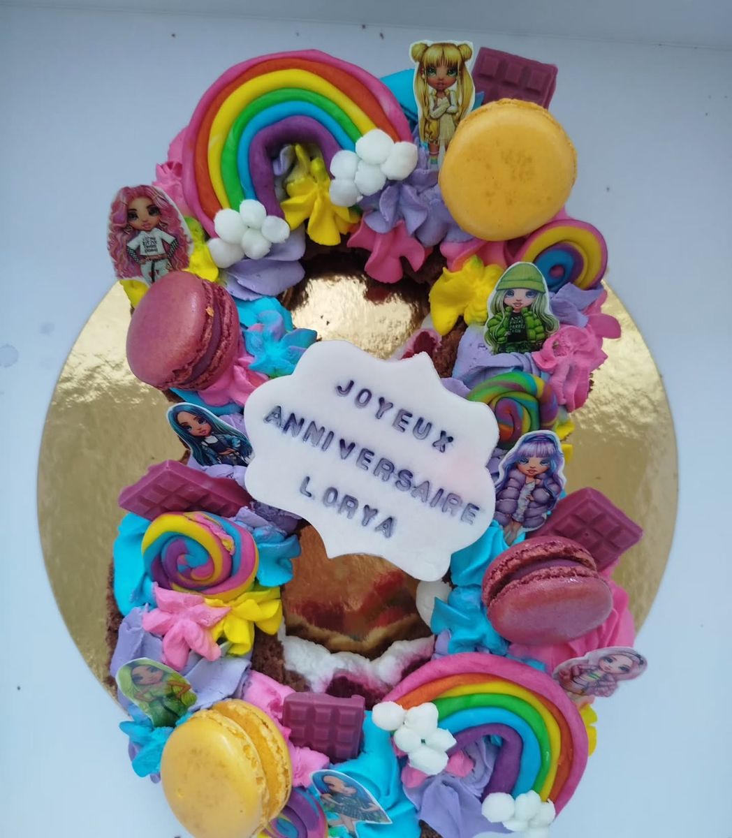 Number cake arc-en-ciel avec macarons, chocolats et plaque « Joyeux anniversaire »